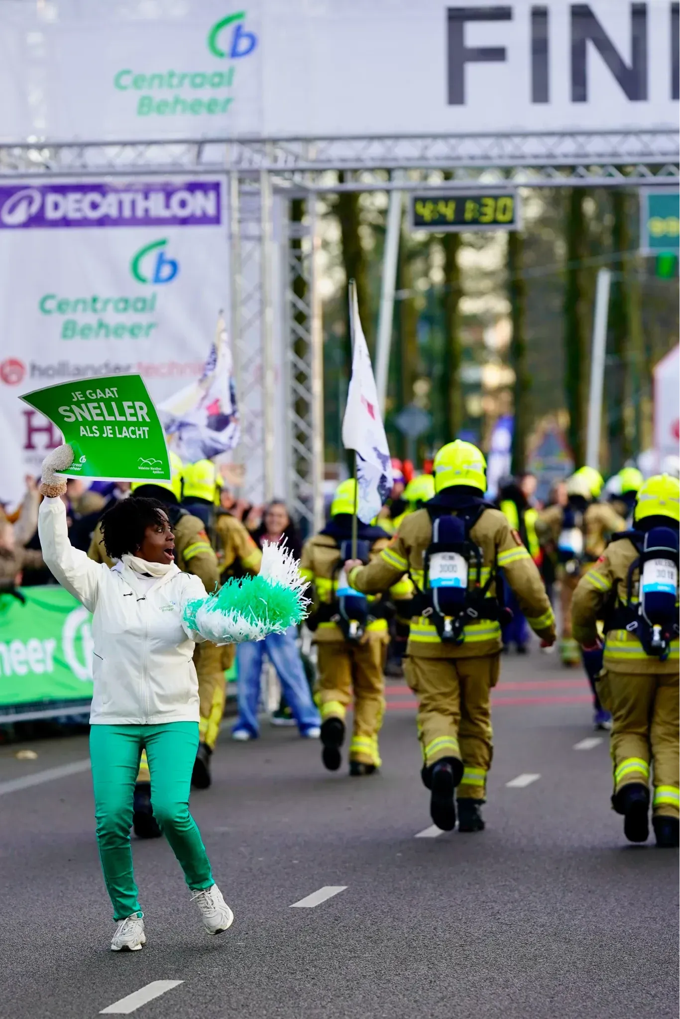 Brandweerlopers tijdens de Midwinter Marathon Apeldoorn op de route onder de startboog.