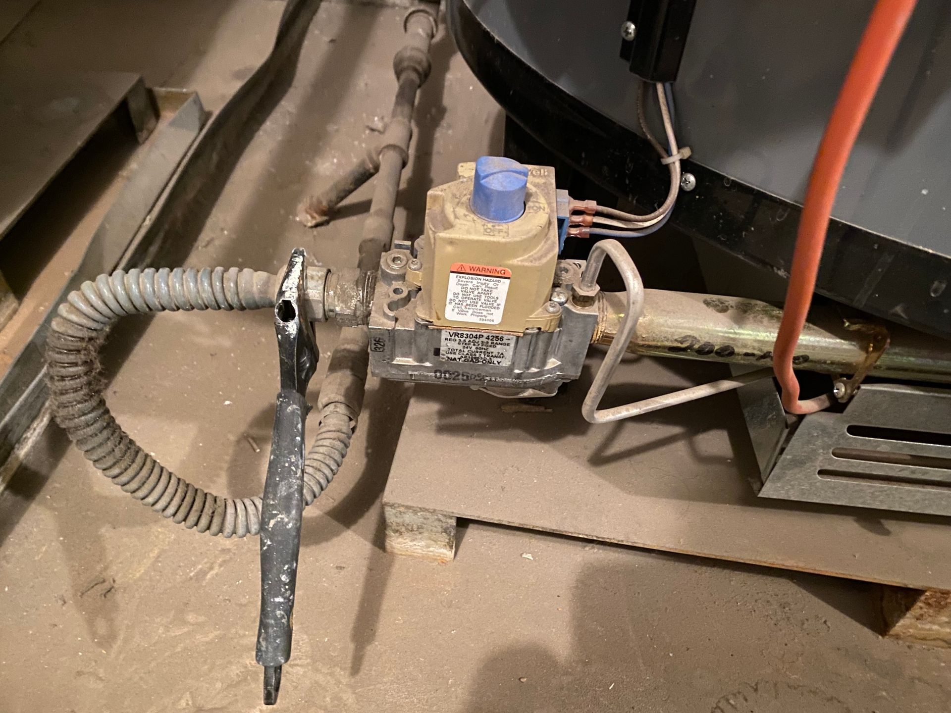 A valve with a blue cap is connected to a pipe.