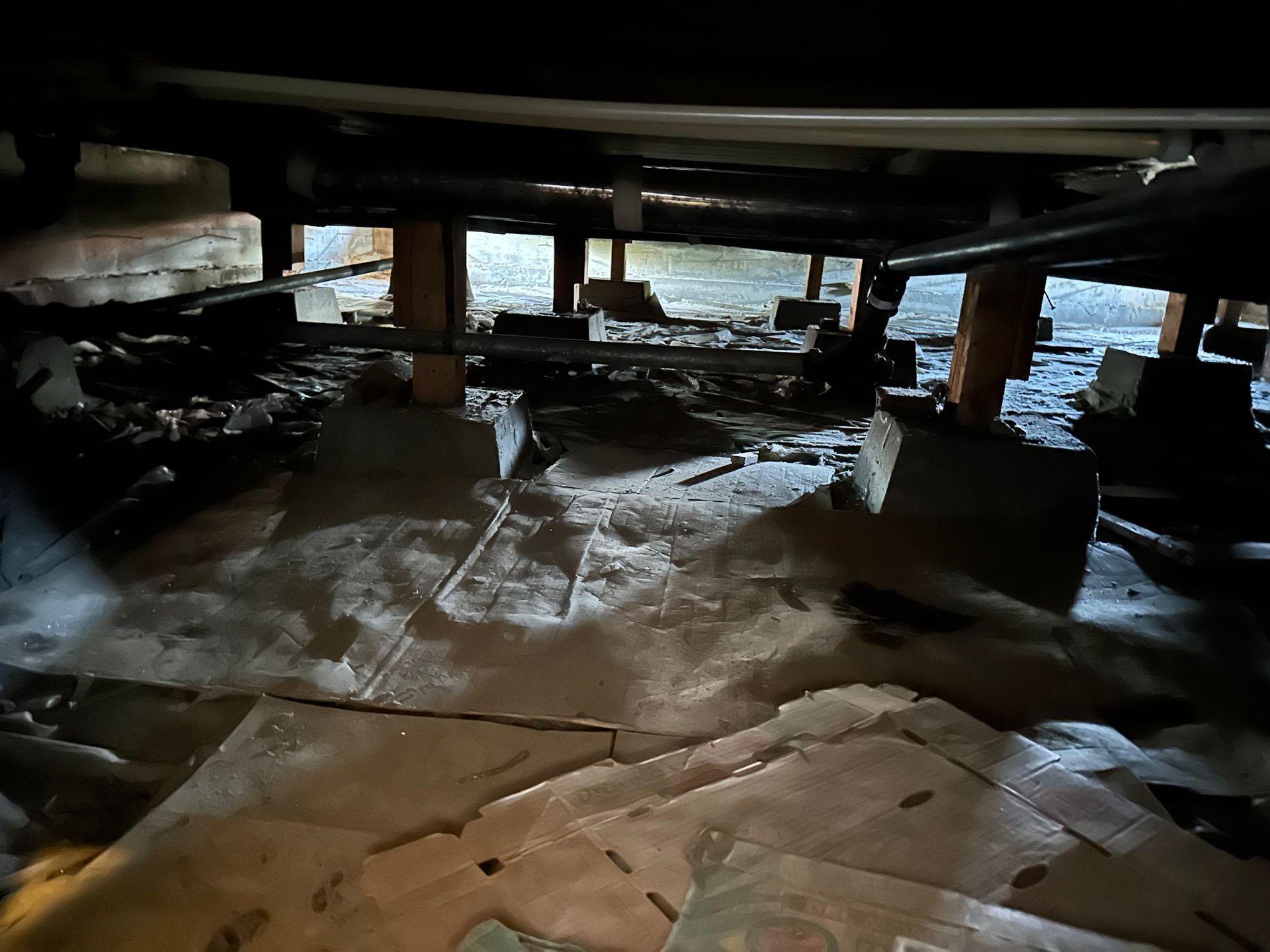 A dark room with a lot of junk on the floor.