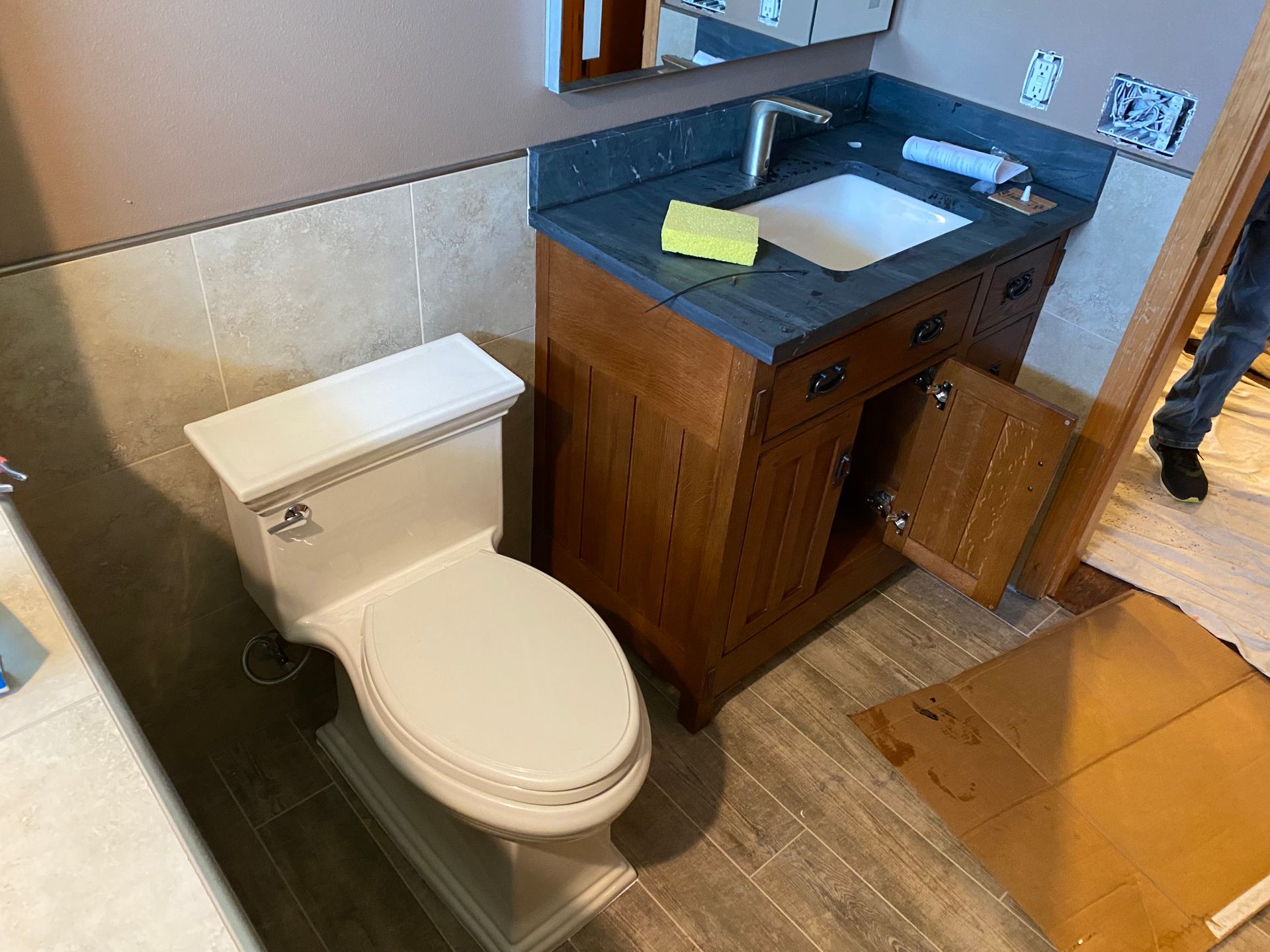 A bathroom with a toilet , sink and vanity.