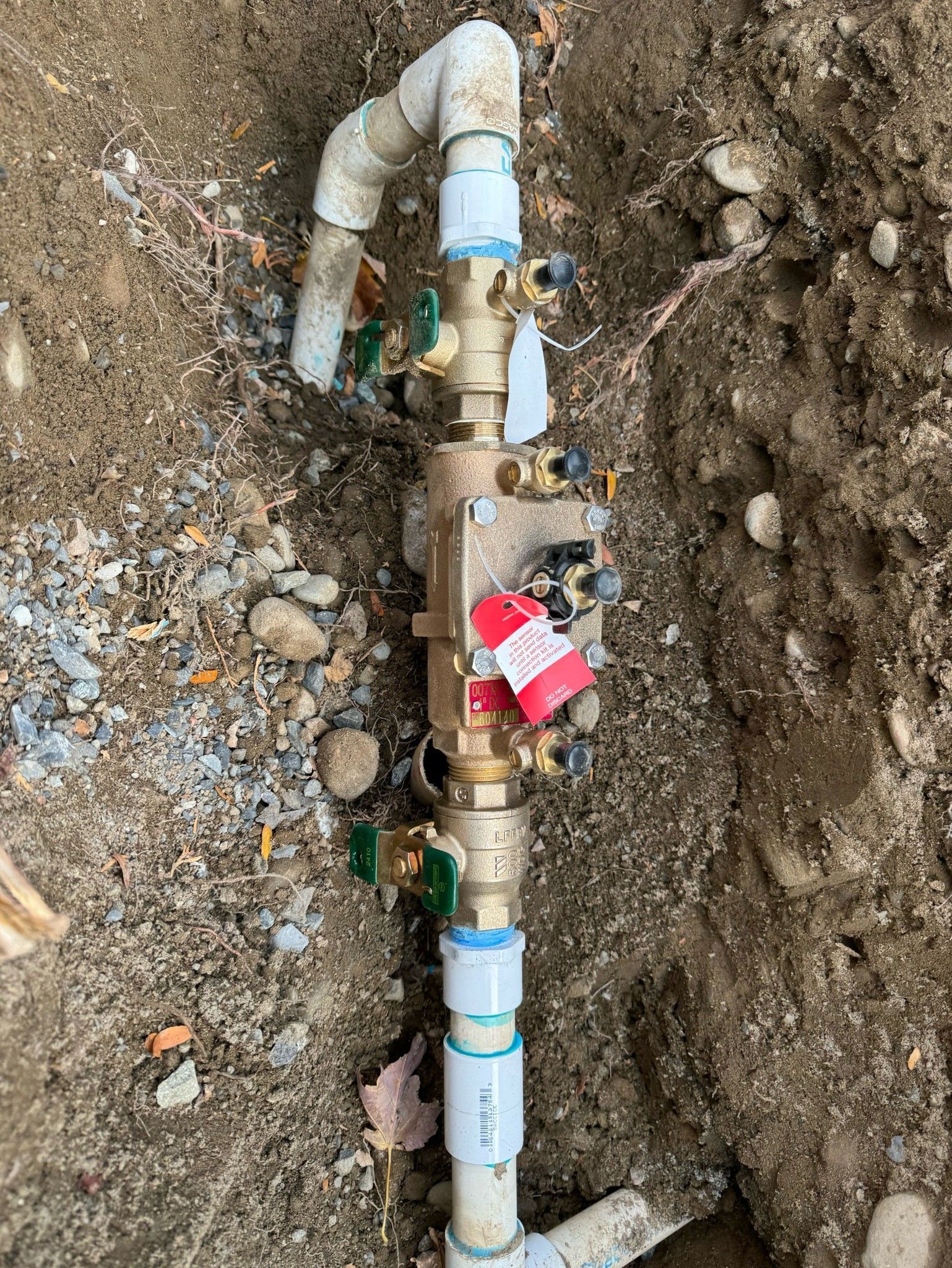 A close up of a water pipe in the dirt.