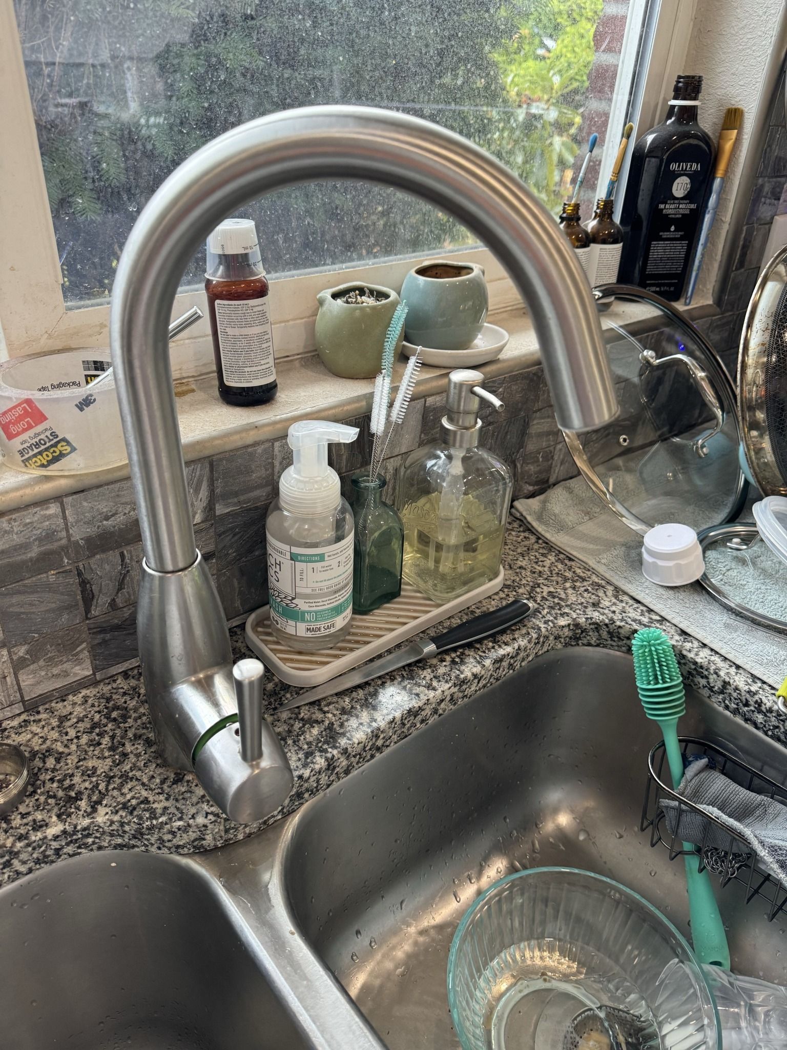 A kitchen sink with a faucet and a bowl in it.