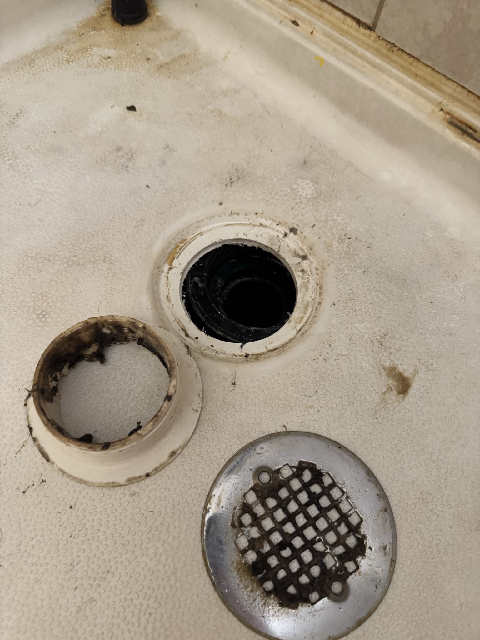 A close up of a shower drain with two holes in it.