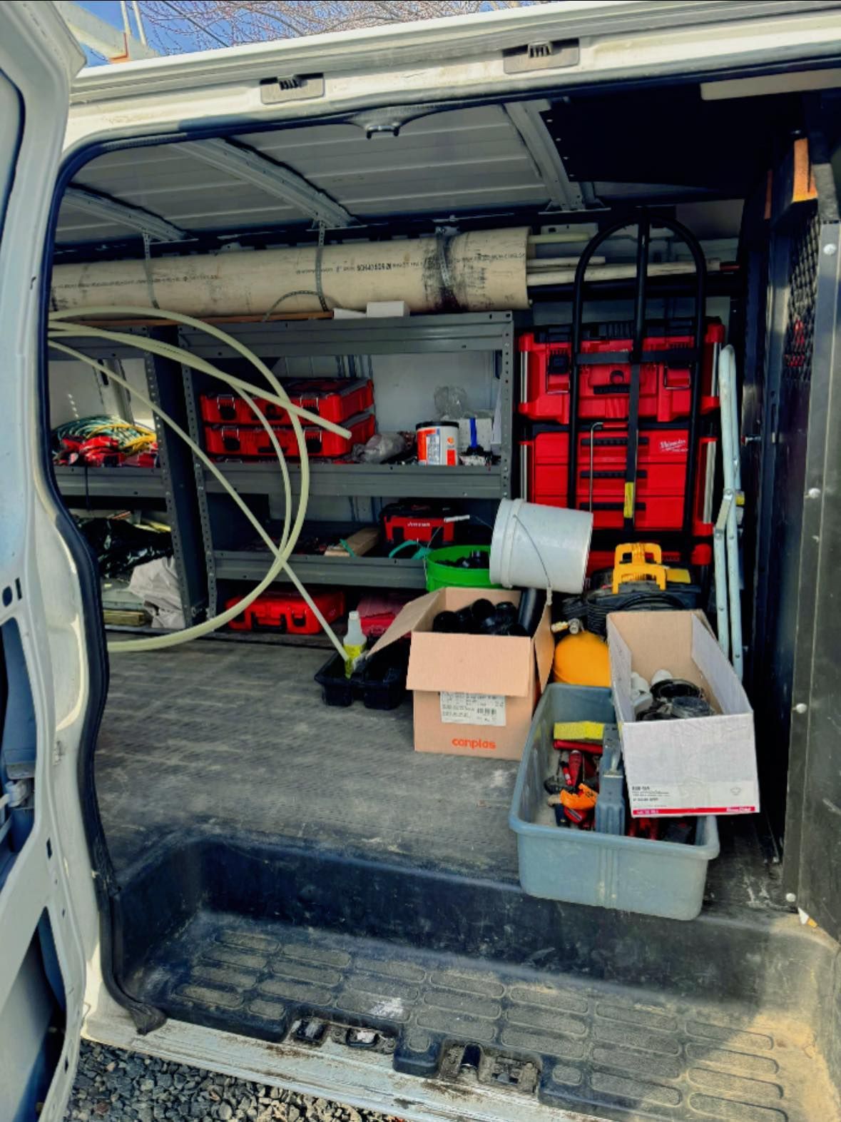 The back of a van filled with tools and boxes.