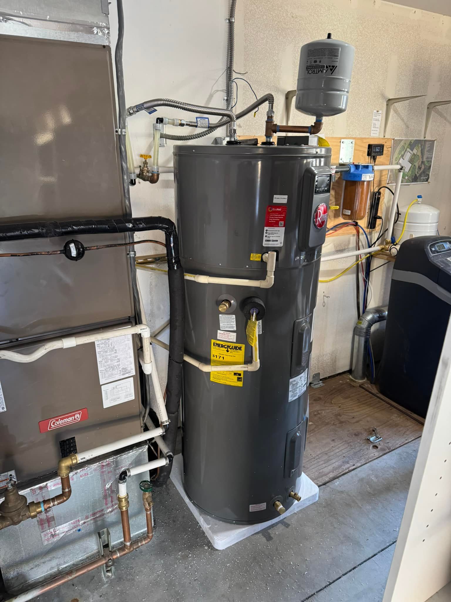 A water heater is sitting in a room next to a wall.