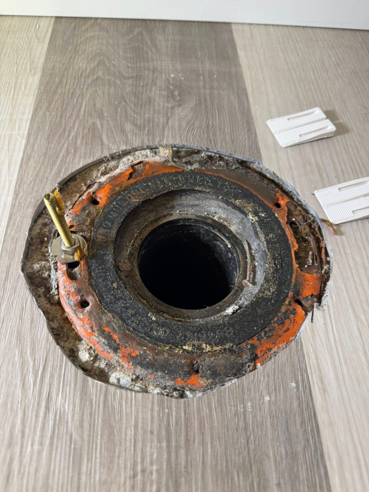 A hole in the floor with a screw in it.