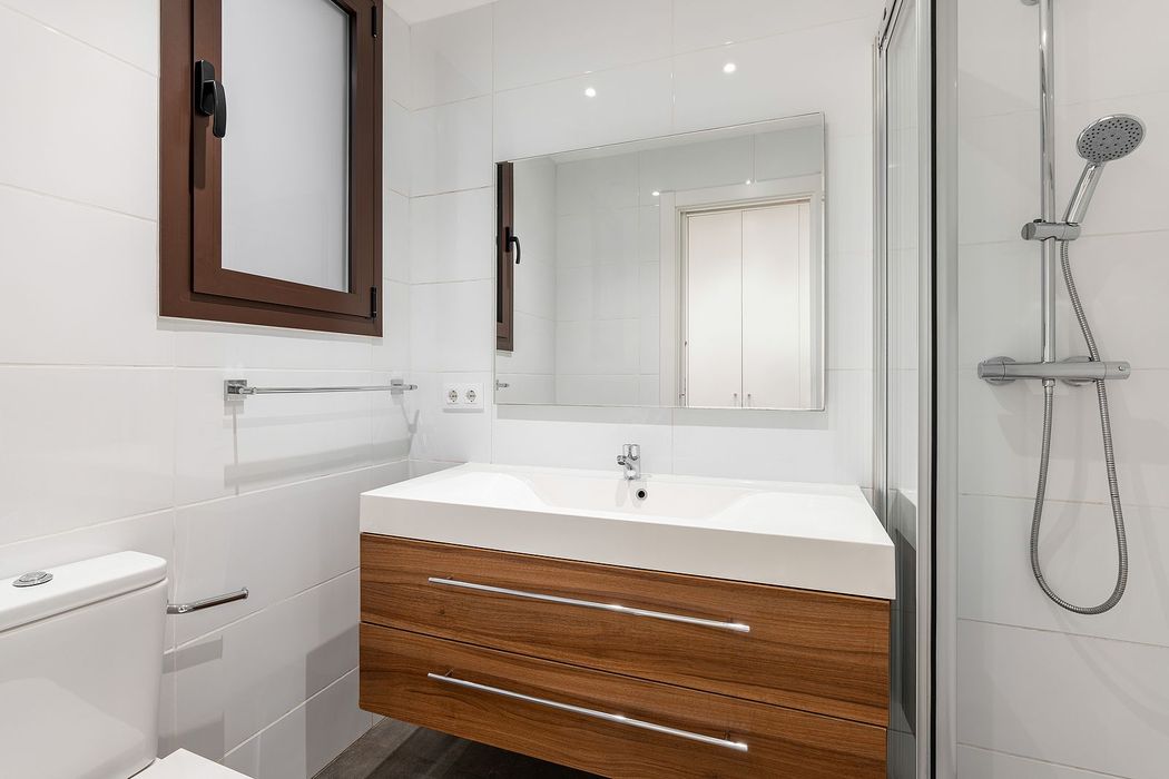 A bathroom with a sink , toilet and shower.