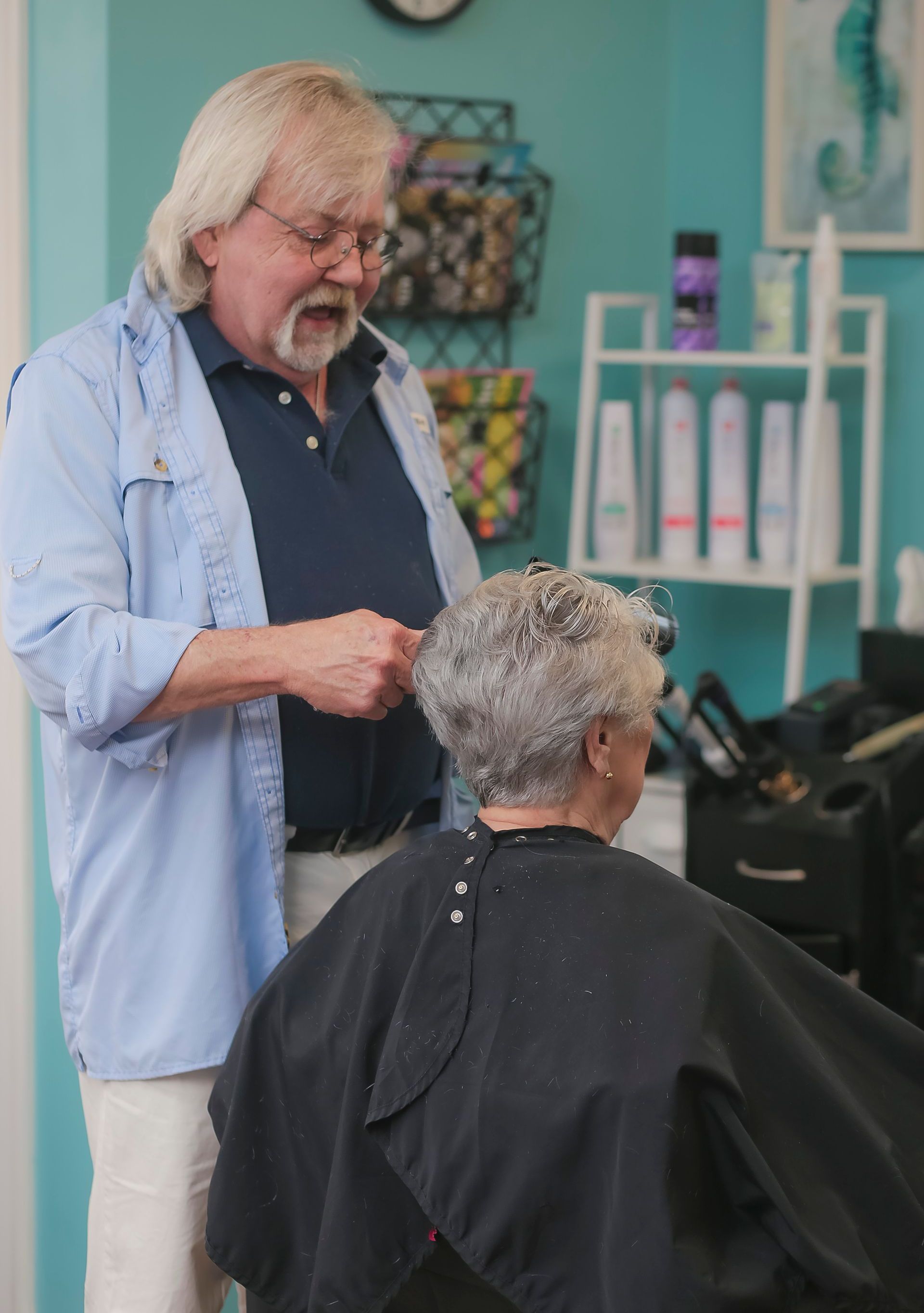 A woman is getting her hair dyed by a hairdresser in a salon.