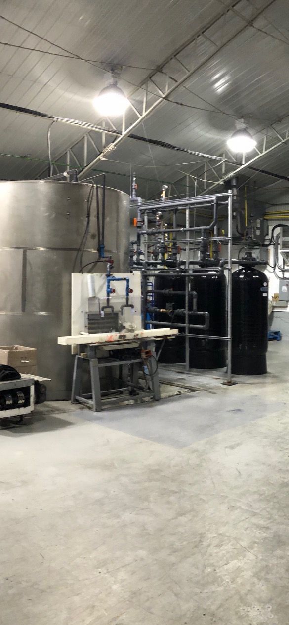 A large warehouse with a lot of tanks and a table.