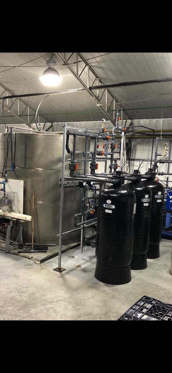 A room with a lot of tanks and pipes in it.