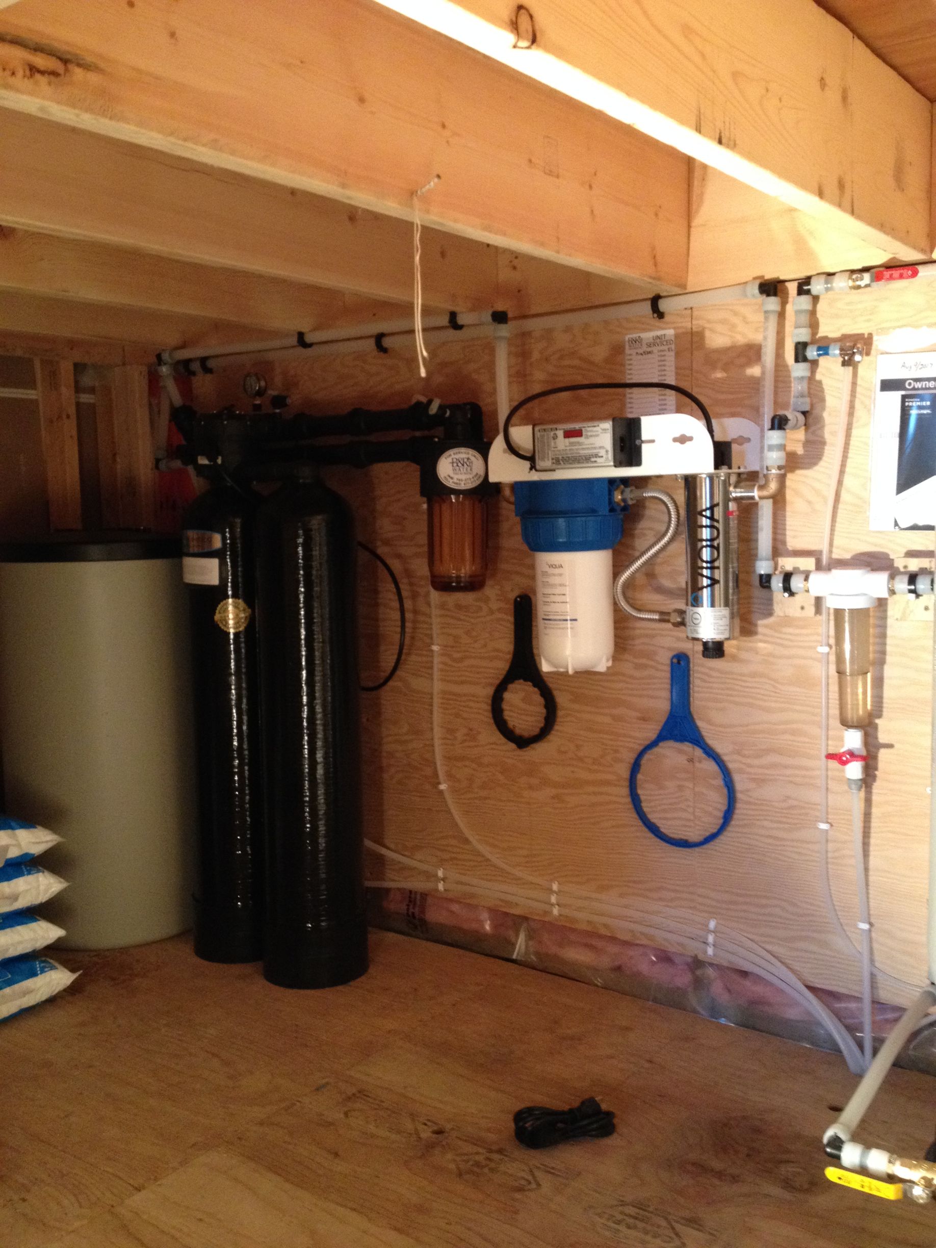 A blue wrench is hanging from a pipe in a room