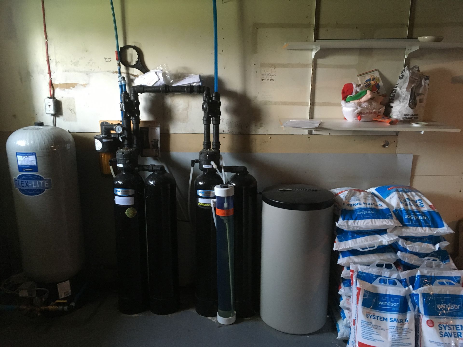 A room with a bunch of water heaters and bags of salt