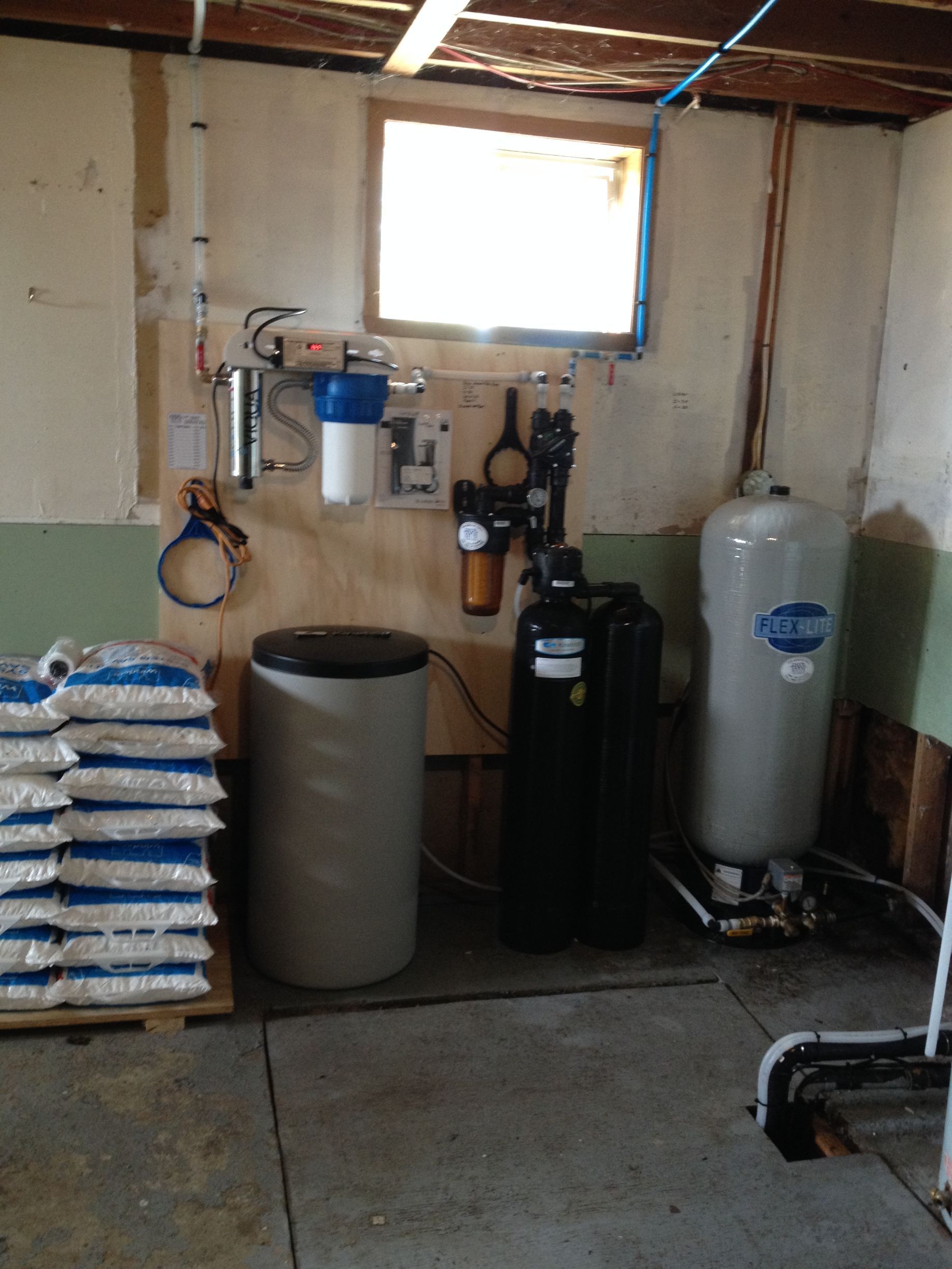 A room with a stack of bags and a water tank