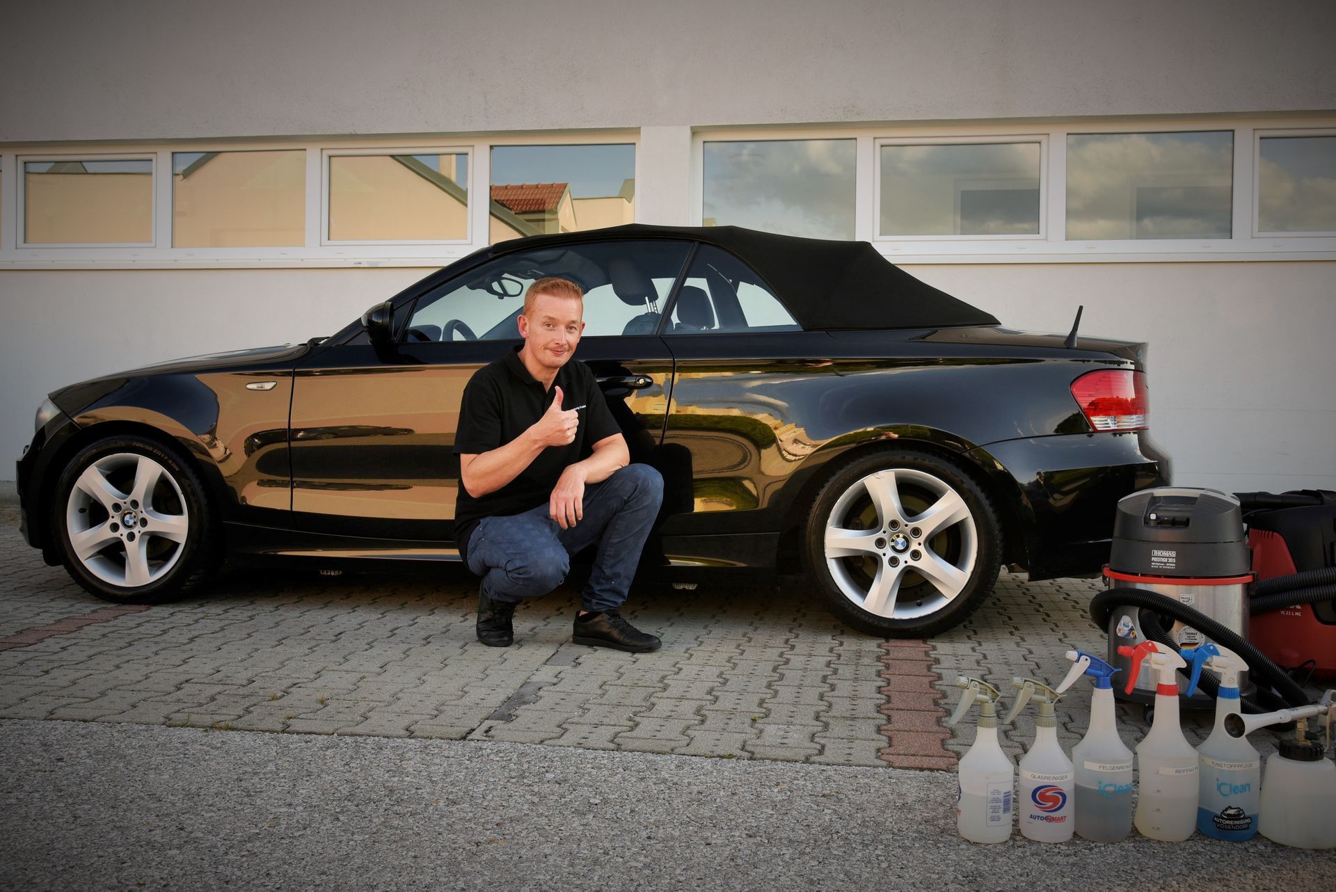 Mitarbeiter vor einem sauber gereinigtem Auto