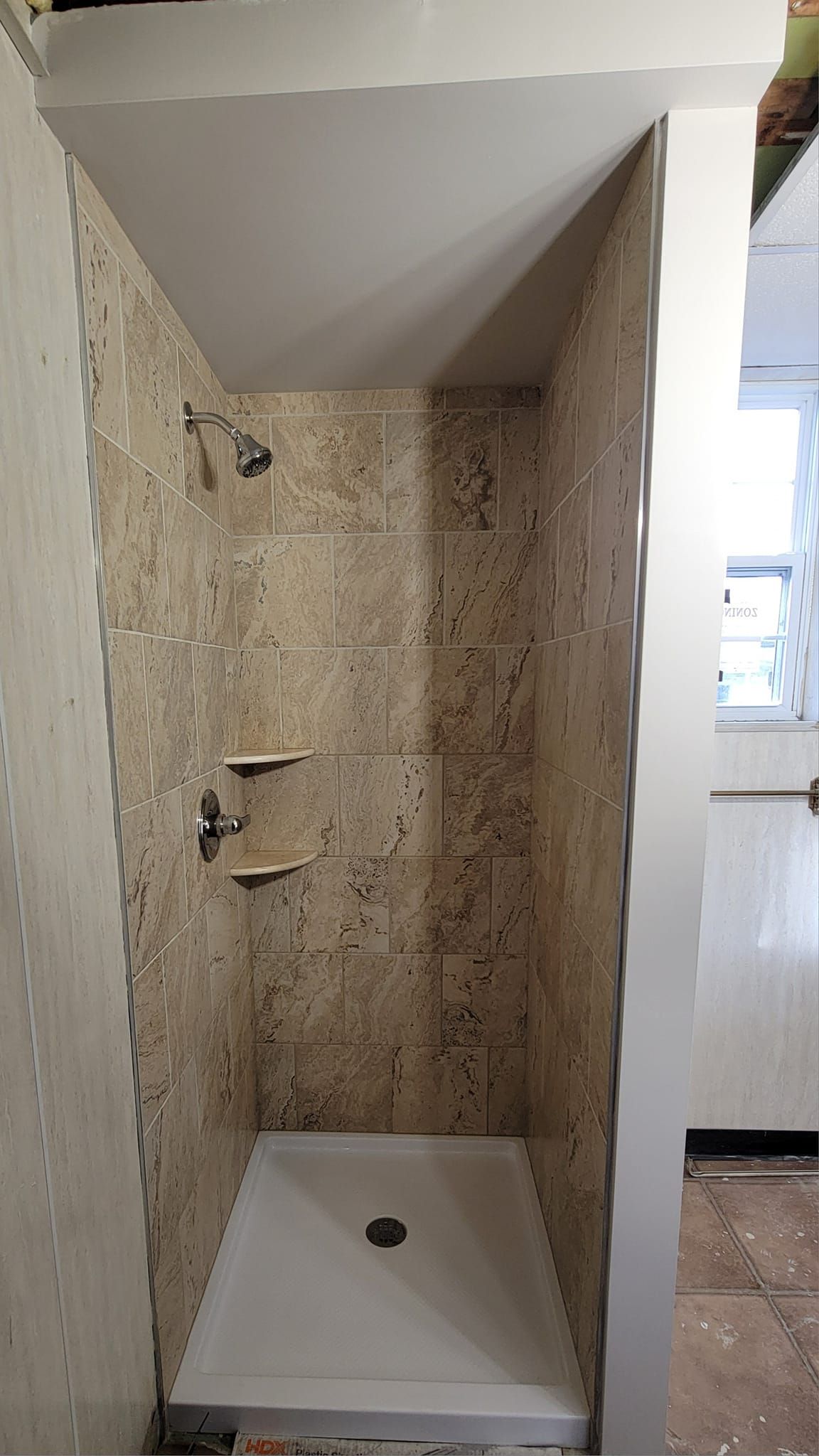 A bathroom with a shower stall and a shower head.