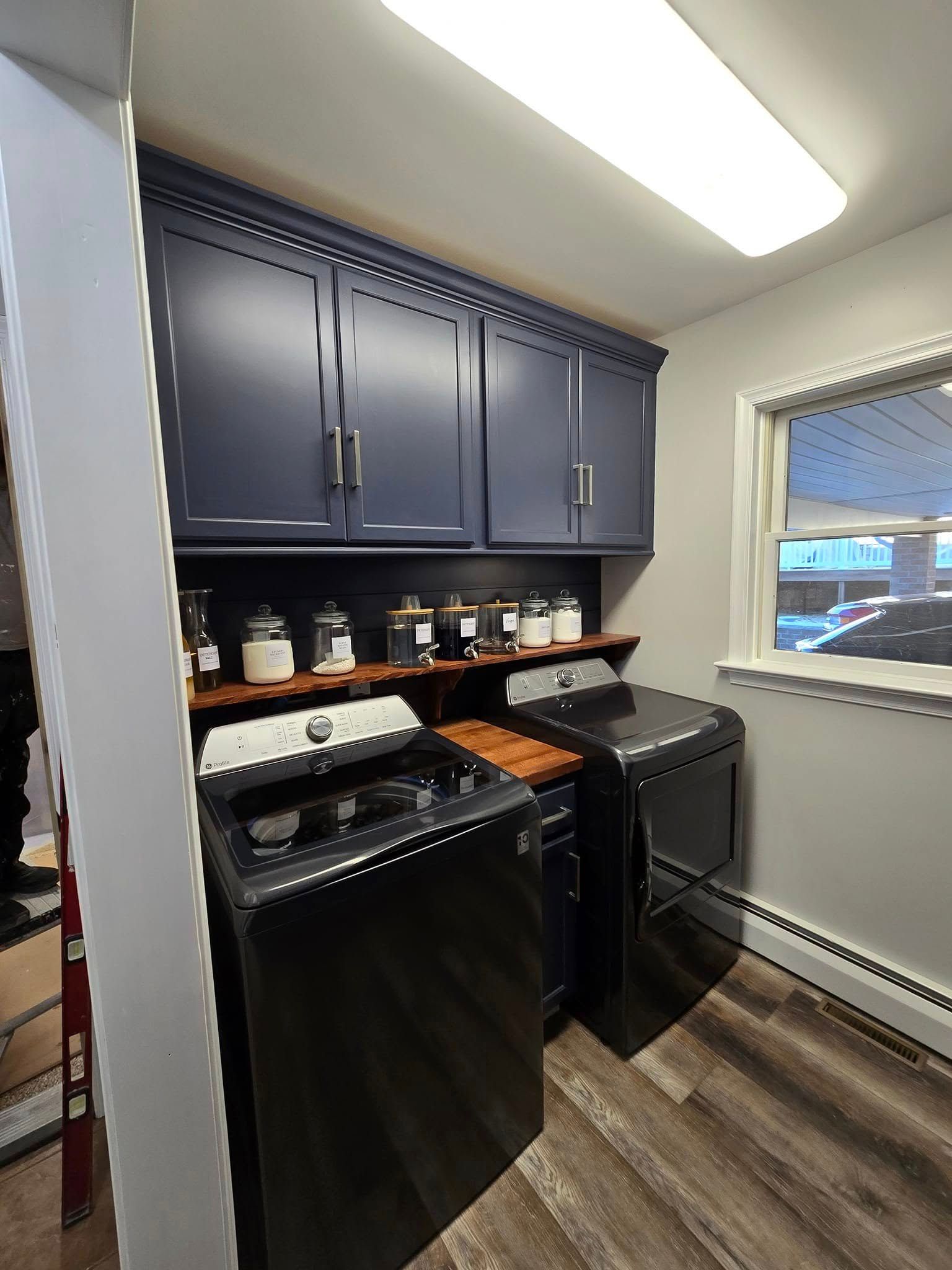 A laundry room with a washer and dryer and blue cabinets.