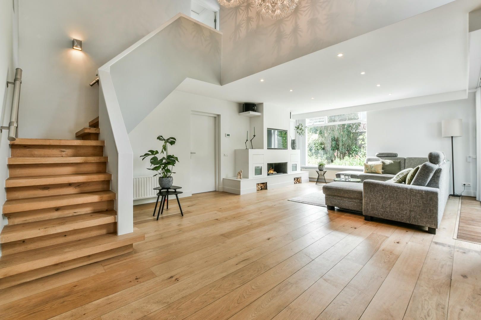 A living room with hardwood floors and stairs leading up to the second floor.