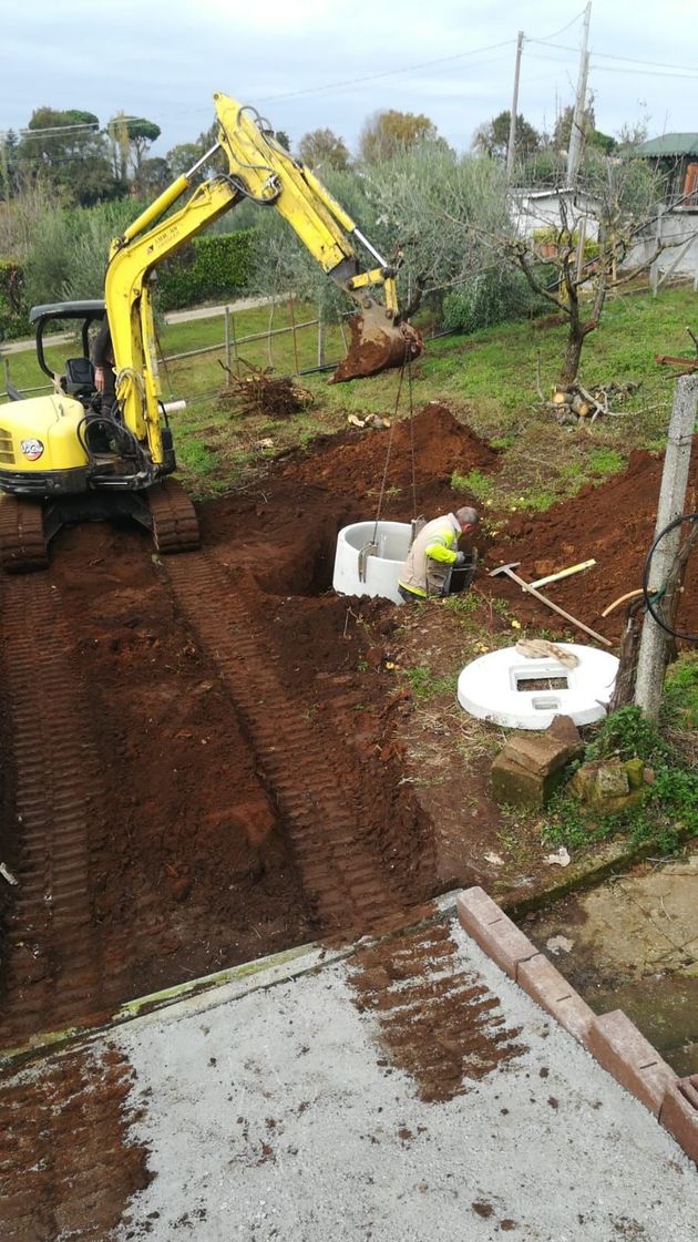 Tecnico che ispeziona un pozzetto e una linea fognaria durante una manutenzione urbana.