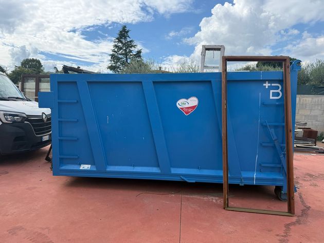Un cassone scarrabile dedicato al legno e al ferro è pronto per il ritiro in un piazzale logistico.