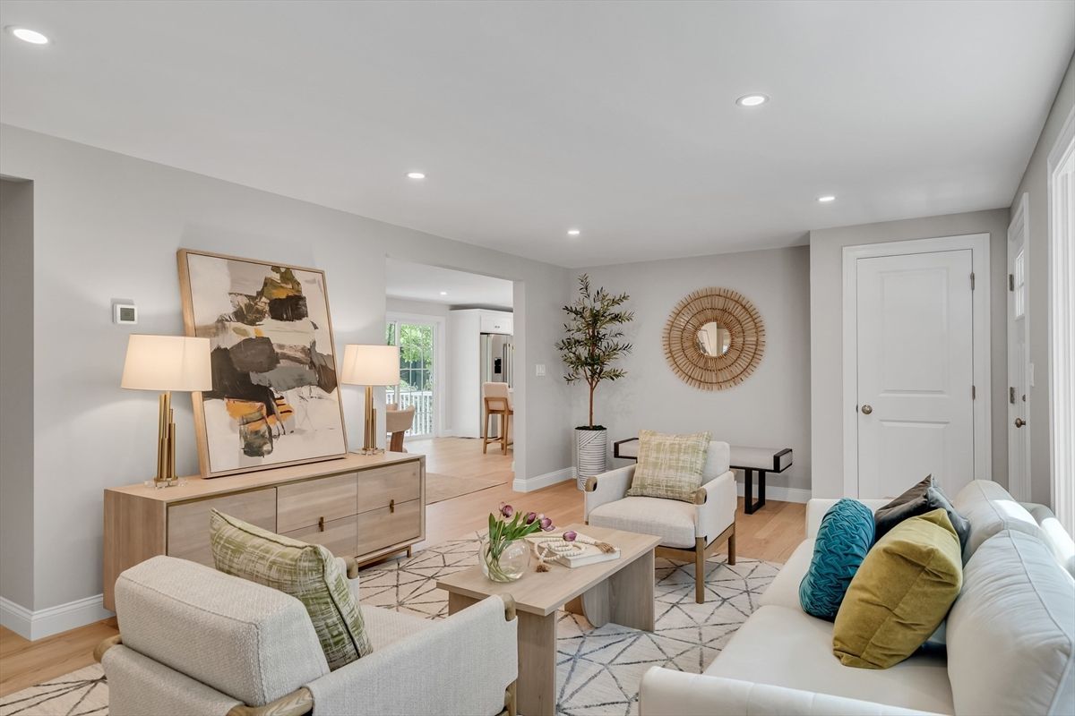 A living room with a couch , chairs , and a coffee table.