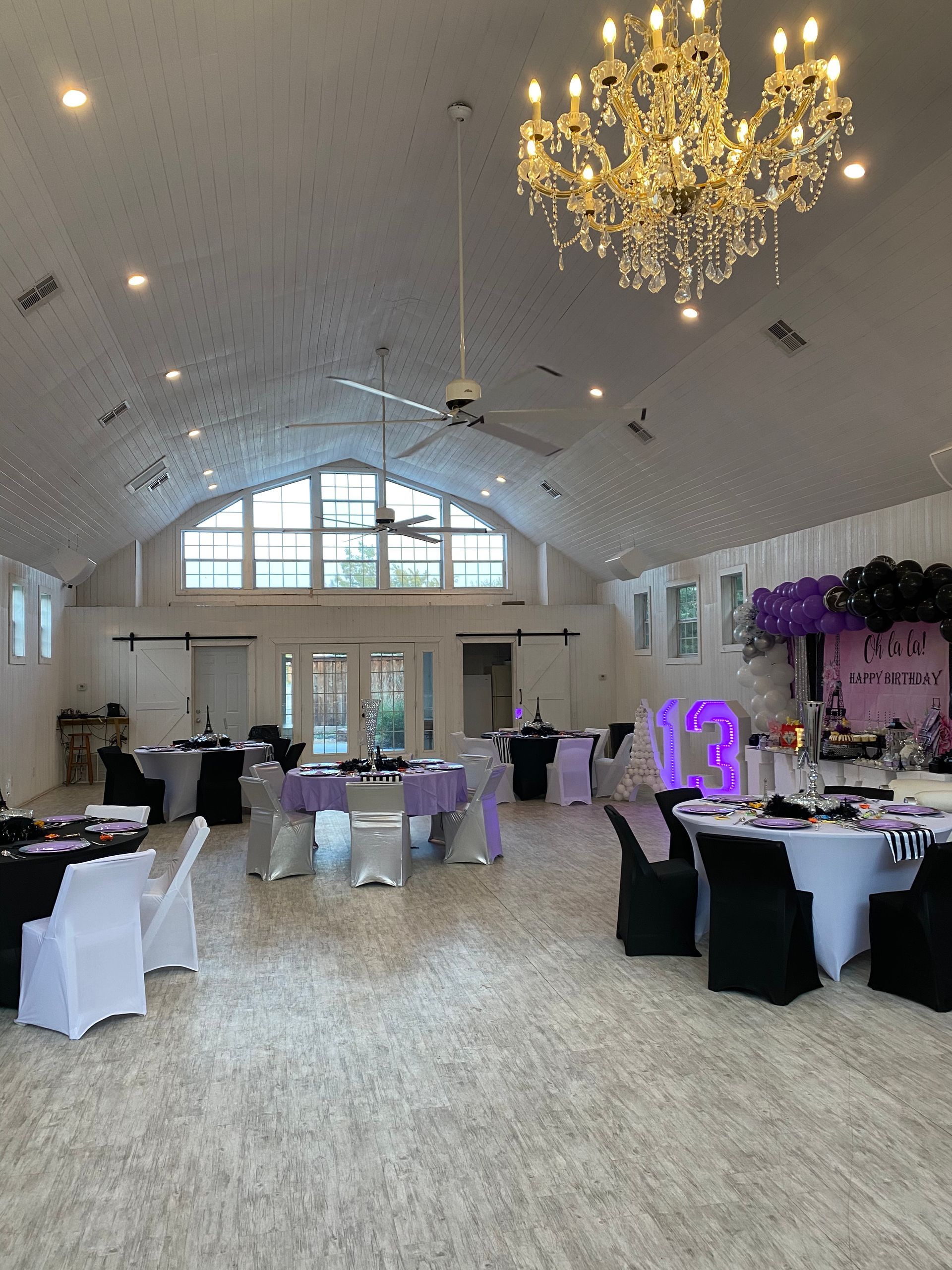 A large room filled with tables and chairs and a chandelier.