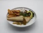 Quesadillas with chips, avocado, beans, and shredded cheese on a white plate.