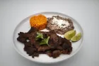 Plate with grilled meat, rice, refried beans, lime wedges, and cilantro.