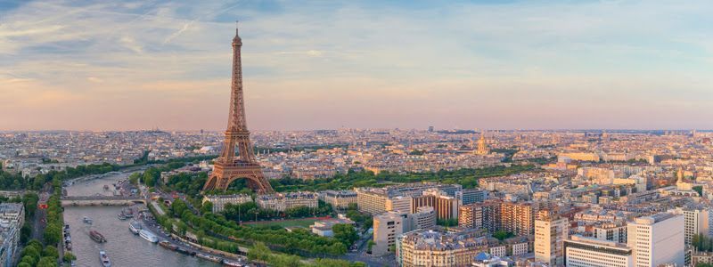 An aerial view of paris with the eiffel tower in the foreground.