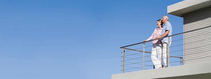 A man and a woman are standing on a balcony.
