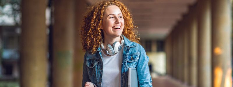 lady-smiling-while-wearing-headphones-around-her-neck