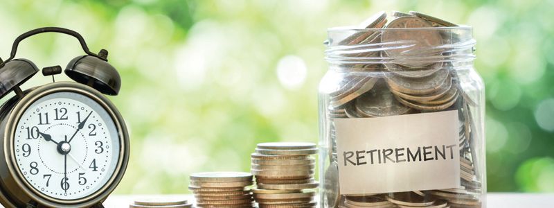 retirement-jar-filled-with-coins-next-to-a-clock