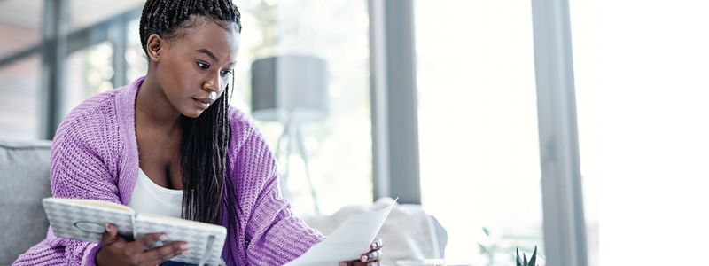 lady-with-notebook-looking-at-a-piece-of-paper