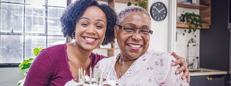 ladies-smiling-with-a-birthday-cake