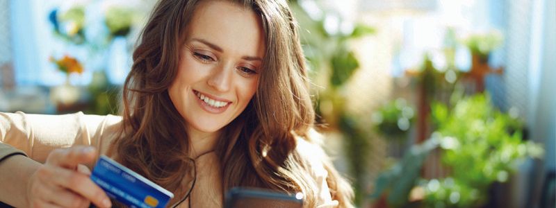 lady-looking-at-her-phone-holding-her-credit-card