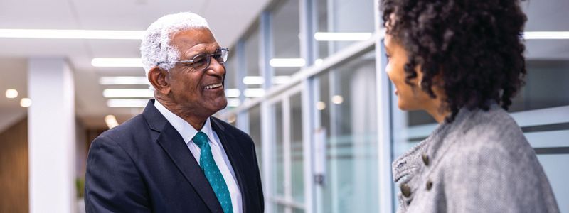 Two people talking in an office hallway