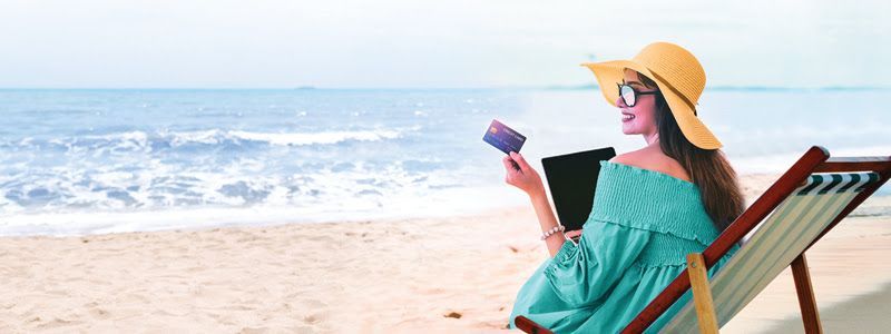A woman is sitting in a beach chair reading a book.