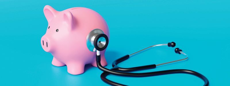 Pink piggy bank with stethoscope on a blue background.