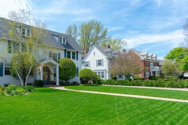 A row of houses with a lush green lawn in front of them.