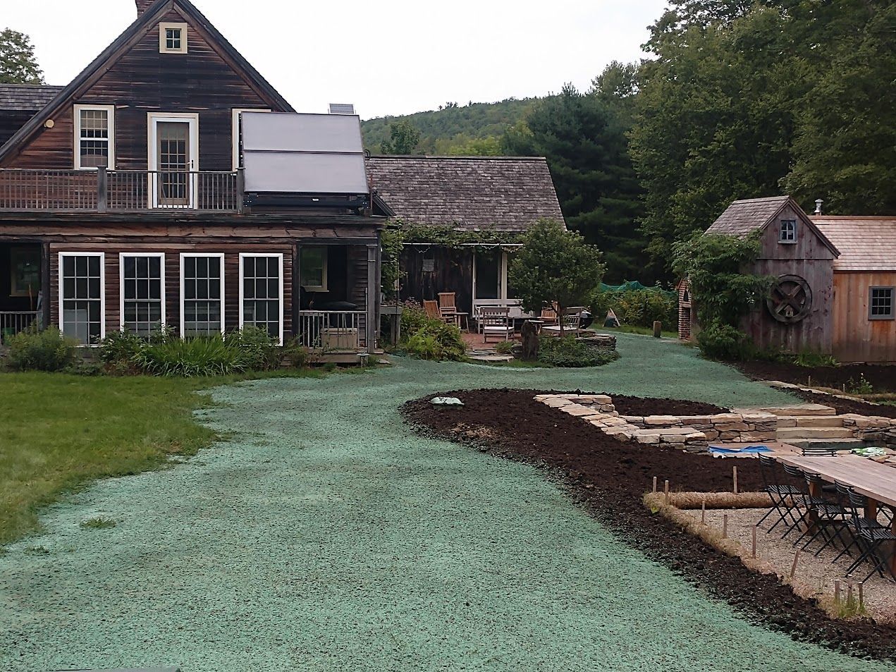 A house with a lot of windows is surrounded by green grass
