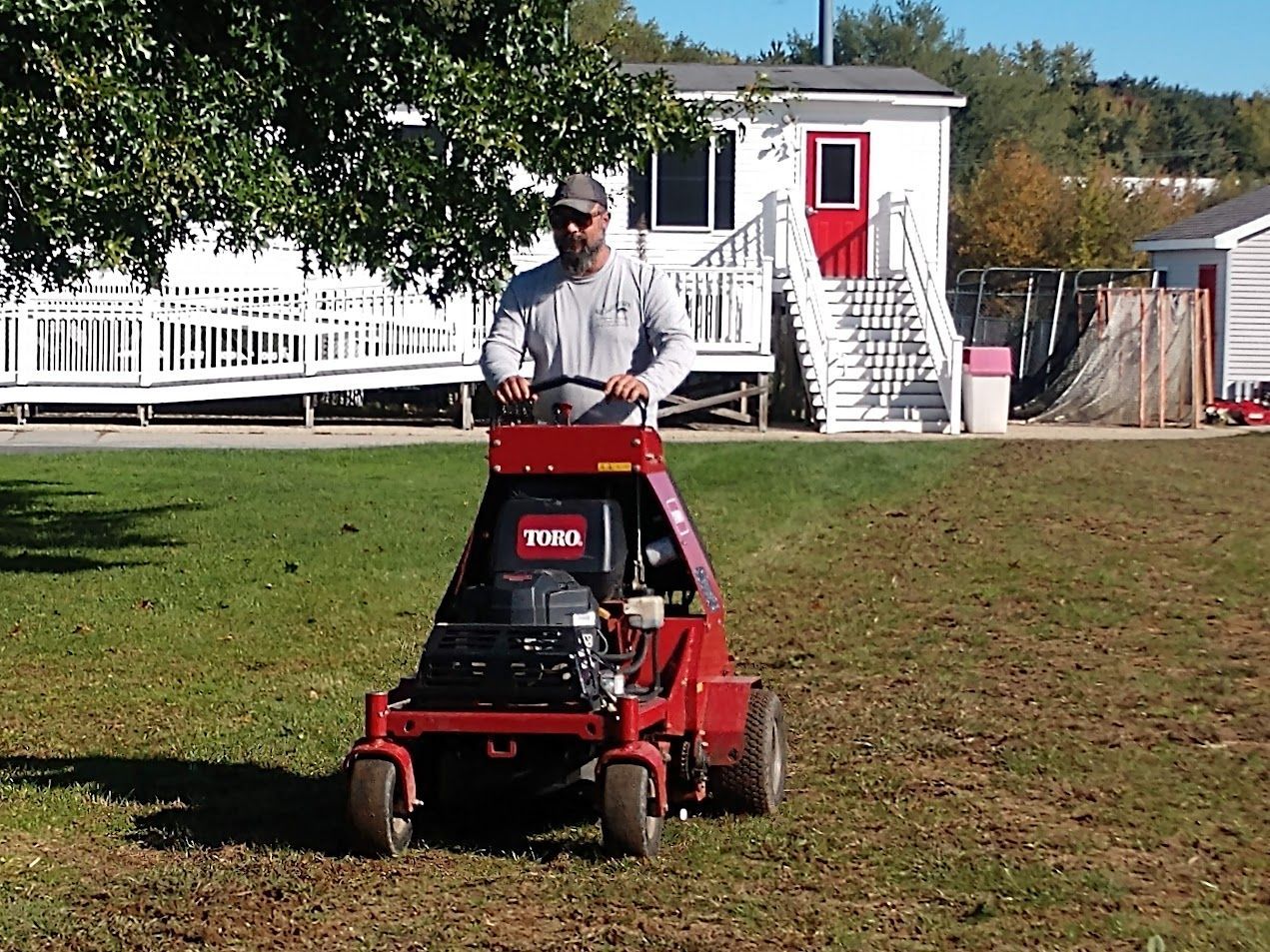 A man is riding a toro lawn mower on a lush green field