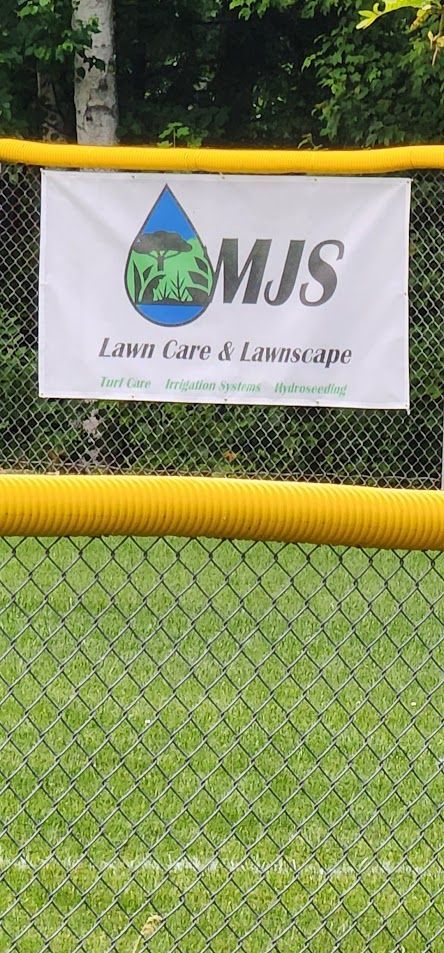 A banner is hanging on a chain link fence.