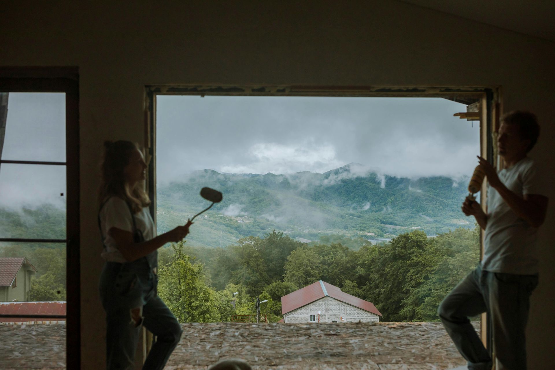girl talking to guy in a house with a mountain backdrop