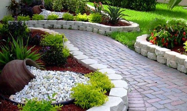 Curving brick pathway through a landscaped garden with raised beds, overflowing pots, and lush greenery. Curving brick pathway through a landscaped garden with raised beds, overflowing pots, and lush greenery.