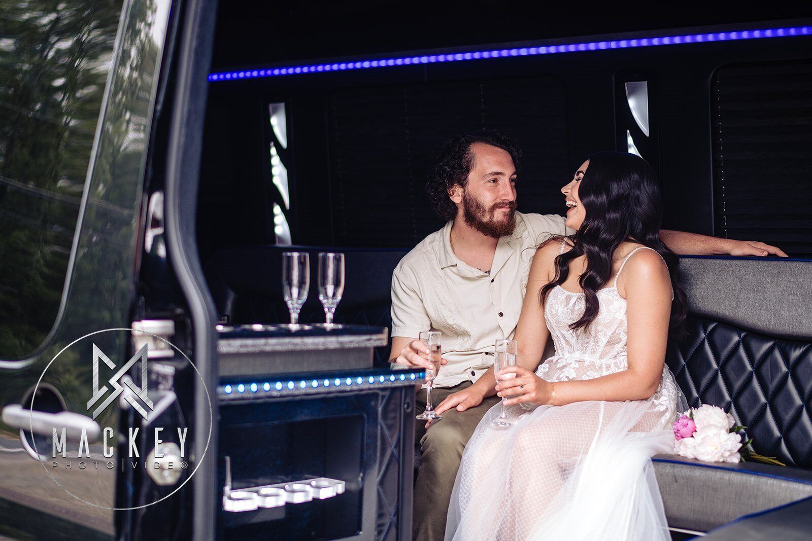 A bride and groom are sitting in a limousine.