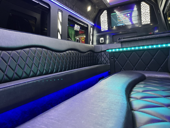 The inside of a limousine with blue lights and a television.