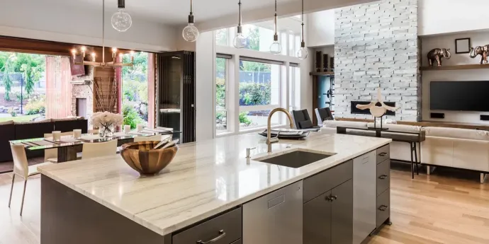A kitchen with a large island in the middle and a sink.