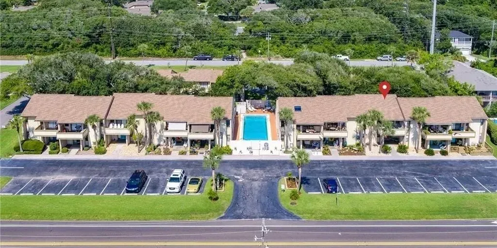 An aerial view of a building with a pool in the middle