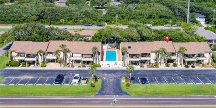 An aerial view of a building with a pool in the middle