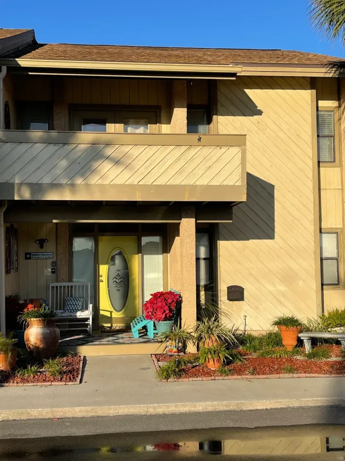 A house with a yellow door and a balcony
