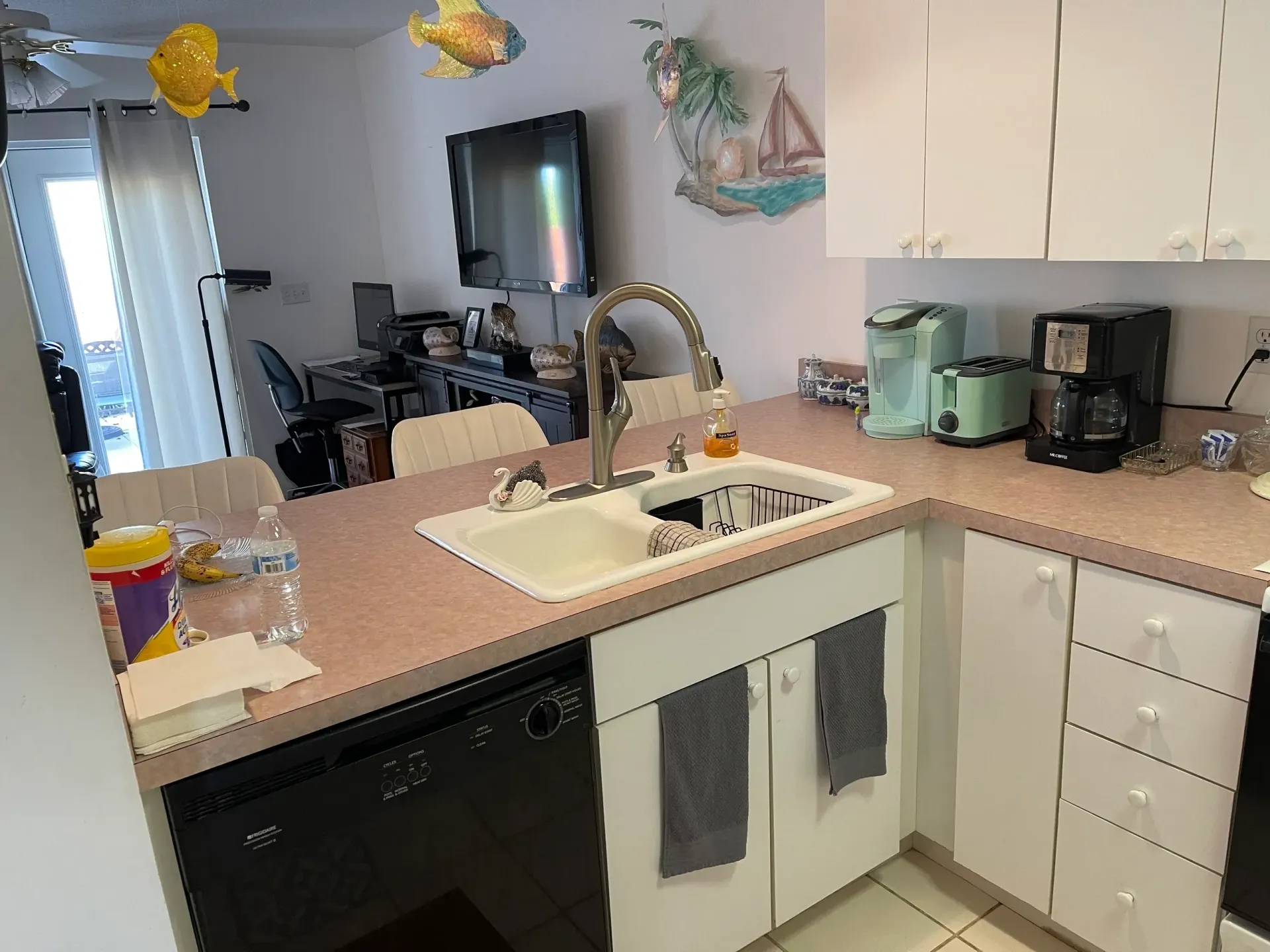A kitchen with a sink and a black dishwasher